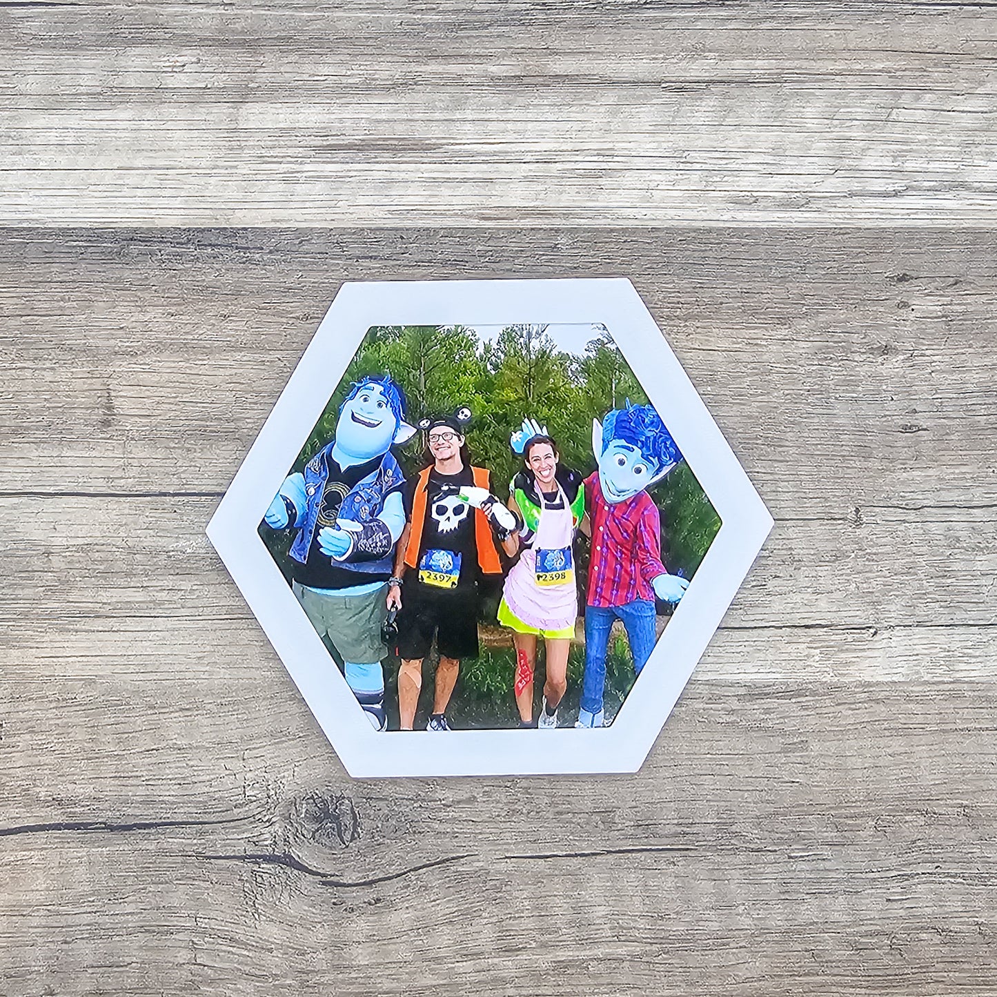 white hexagon shaped picture frame top for a running medal display shown with a picture included