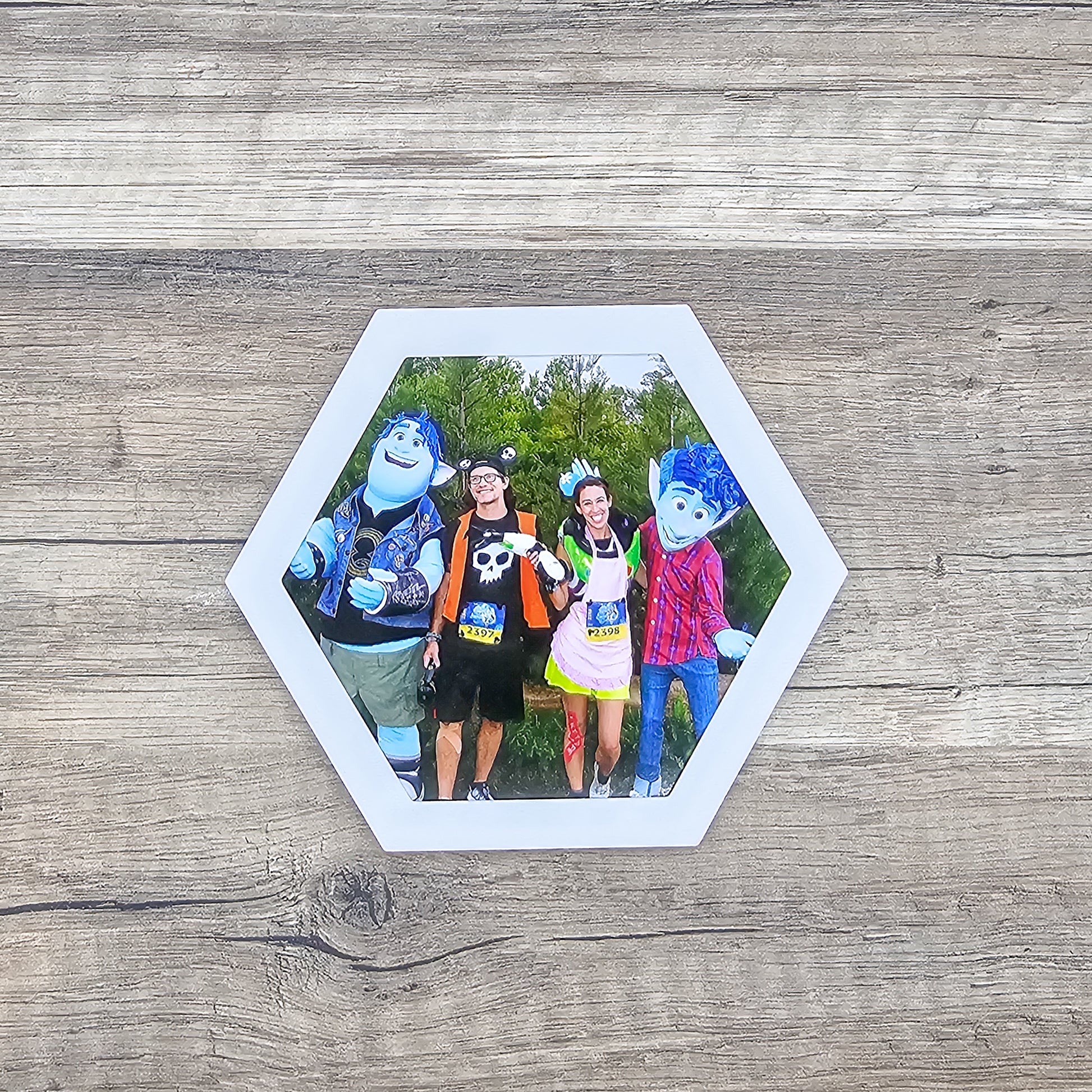 white hexagon shaped picture frame top for a running medal display shown with a picture included